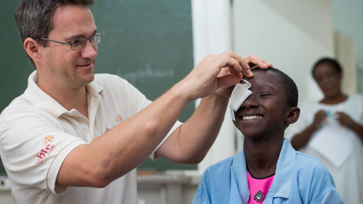 Augenarzt entfernt Augenverband bei einem Kind