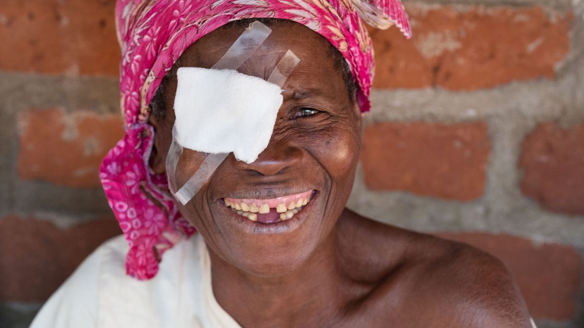 Portrait einer lächelnden Frau mit Augenverband