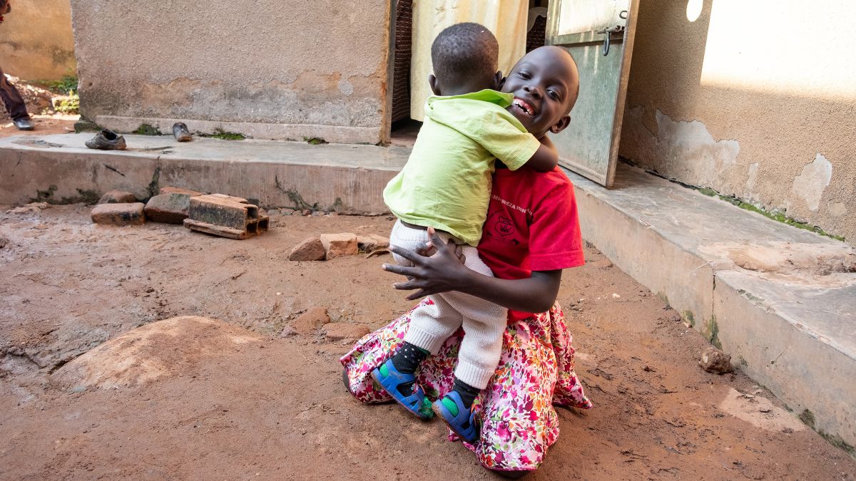 Ein Mädchen wird von einem kleinen Jungen umarmt.