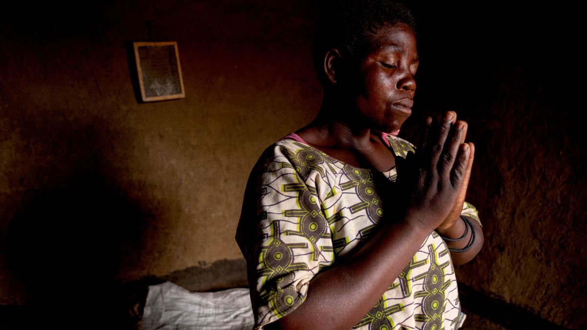 Afrikanische Frau mit zum Beten zusammengelegten Händen