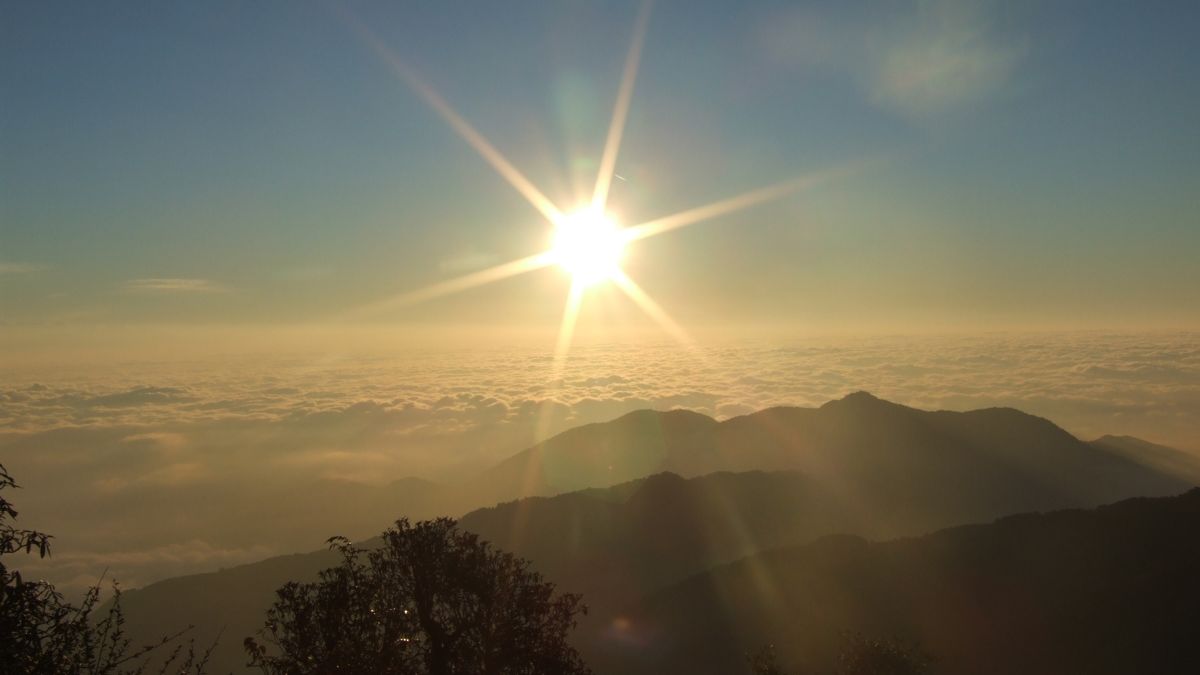 Über Bergen geht die Sonne auf.