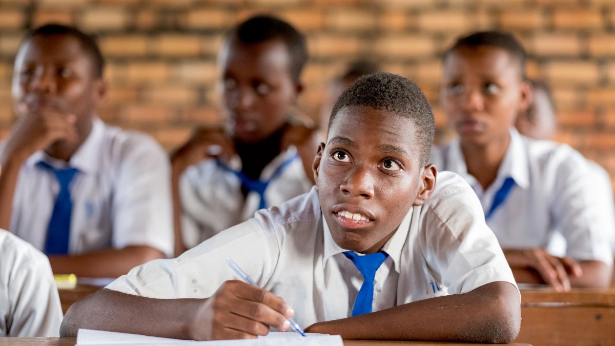 Ein körperbehinderter Junge sitzt mit anderen Jungen in einem Klasssenzimmer.