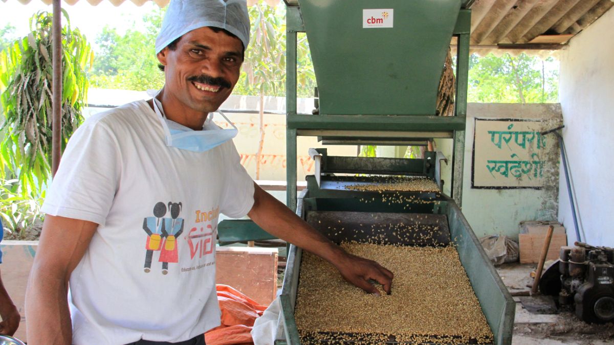Mann steht an der Maschine in seinem Bio-Betrieb.
