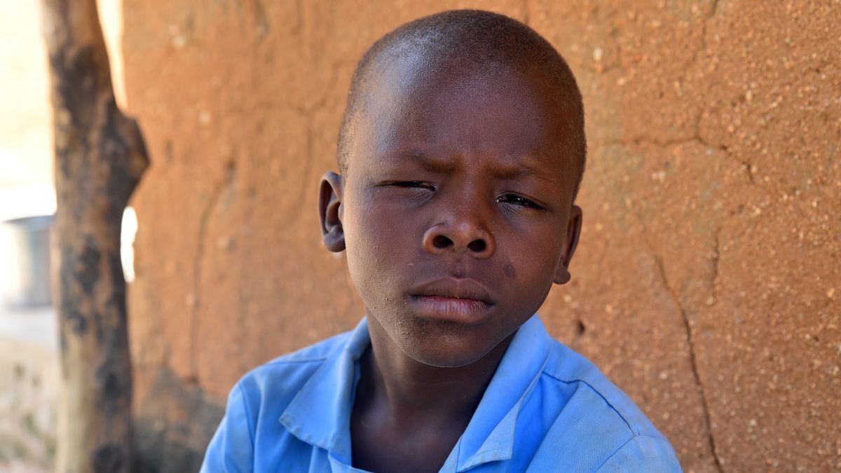 Etwa zehnjähriger Junge mit zusammengekniffenen Augen.