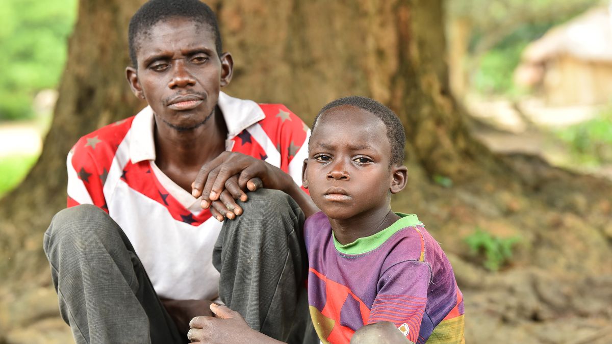 Ein Mann und ein Kind sitzen auf dem Boden. 