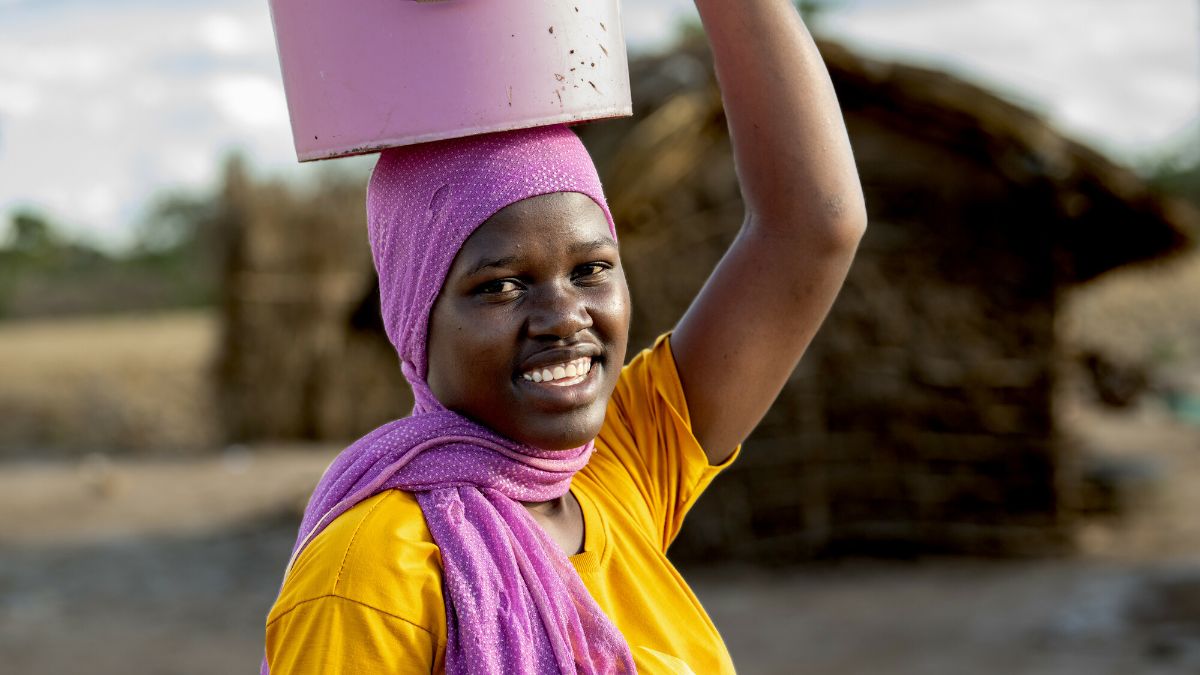 Eine Frau mit einem Eimer auf dem Kopf.