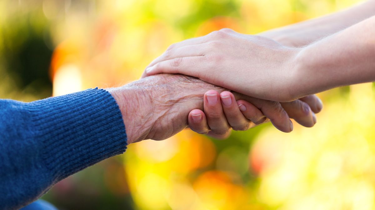 Zwei junge Hände umfassen eine alte Hand.