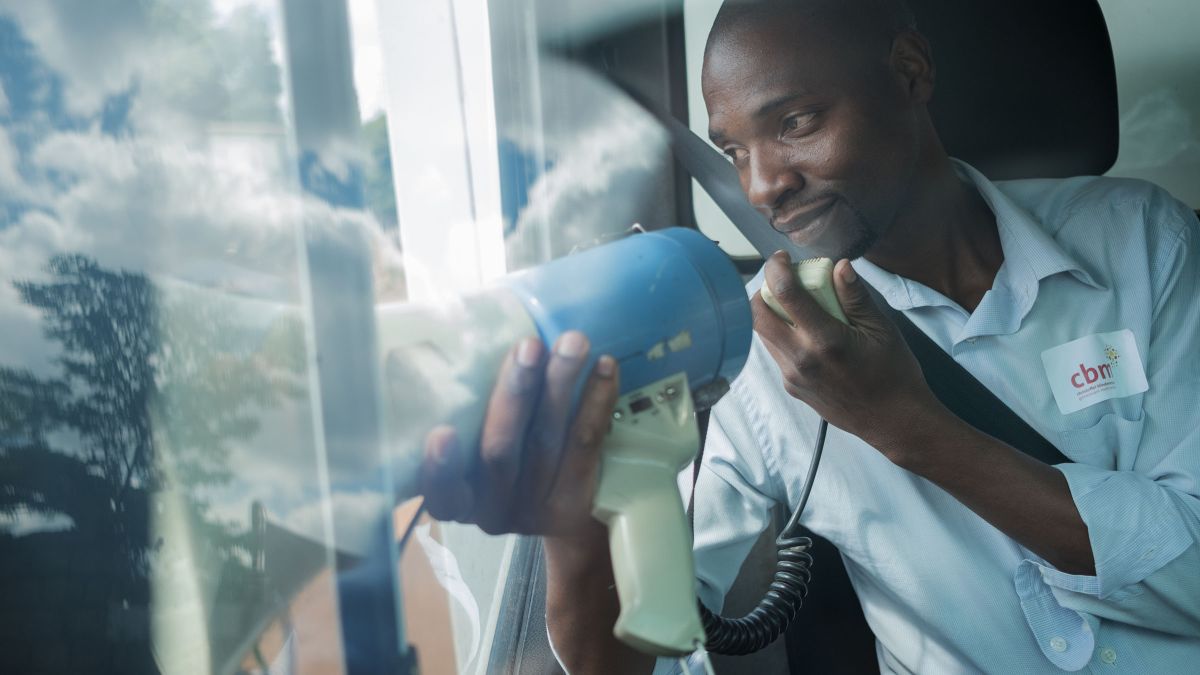 Mann spricht aus einem Auto heraus durch ein Megaphon