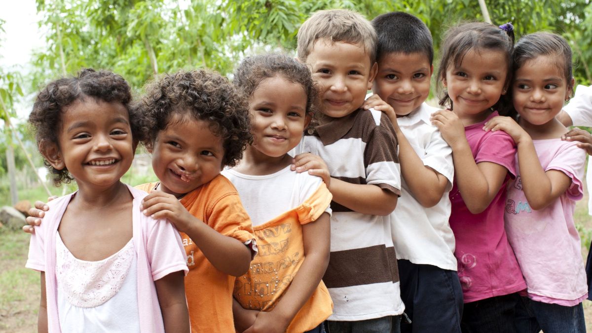 Sieben Kinder stehen in einer Reihe hintereinander
