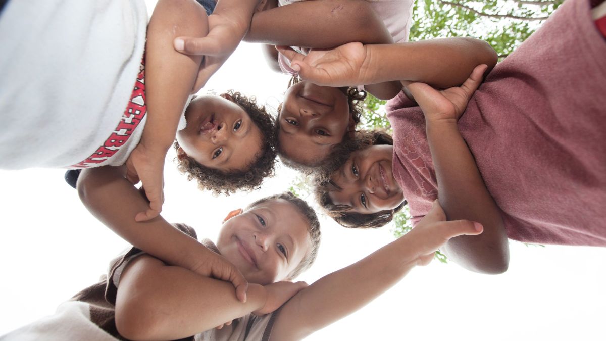 Kinder fassen sich an den Händen und bilden einen Kreis