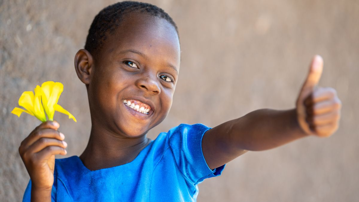 Lächelndes Mädchen hält Blume in der Hand