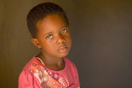 Ein etwa vierjähriges kleines Mädchen mit hell schimmernden Pupillen.