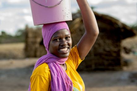 Eine Frau mit einem Eimer auf dem Kopf.