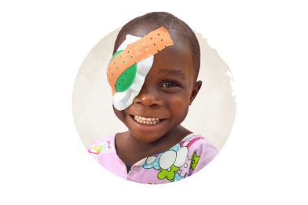 Lachender kleiner Junge mit Verband auf einem Auge.