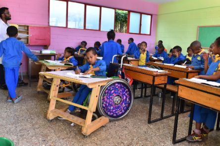 Kinder mit und ohne Rollstuhl in einem Klasenzimmer