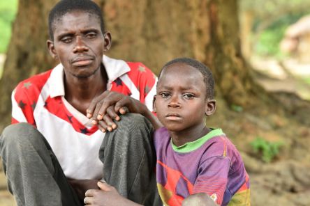 Ein Mann und ein Kind sitzen auf dem Boden. 