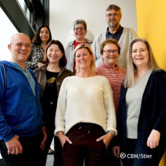 Eine Gruppe von sechs Frauen und zwei Männern stehen auf einer Treppe.