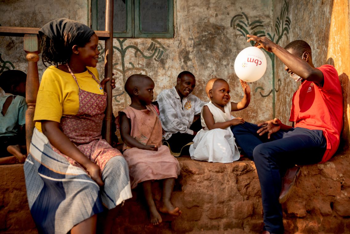 Eine Familie mit CBM Mitarbeiter und Luftballon