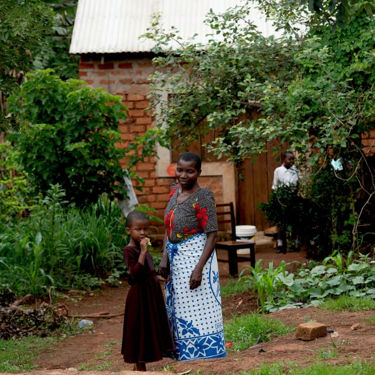 Ein Kind und eine ältere Frau vor einem Backsteinhäuschen