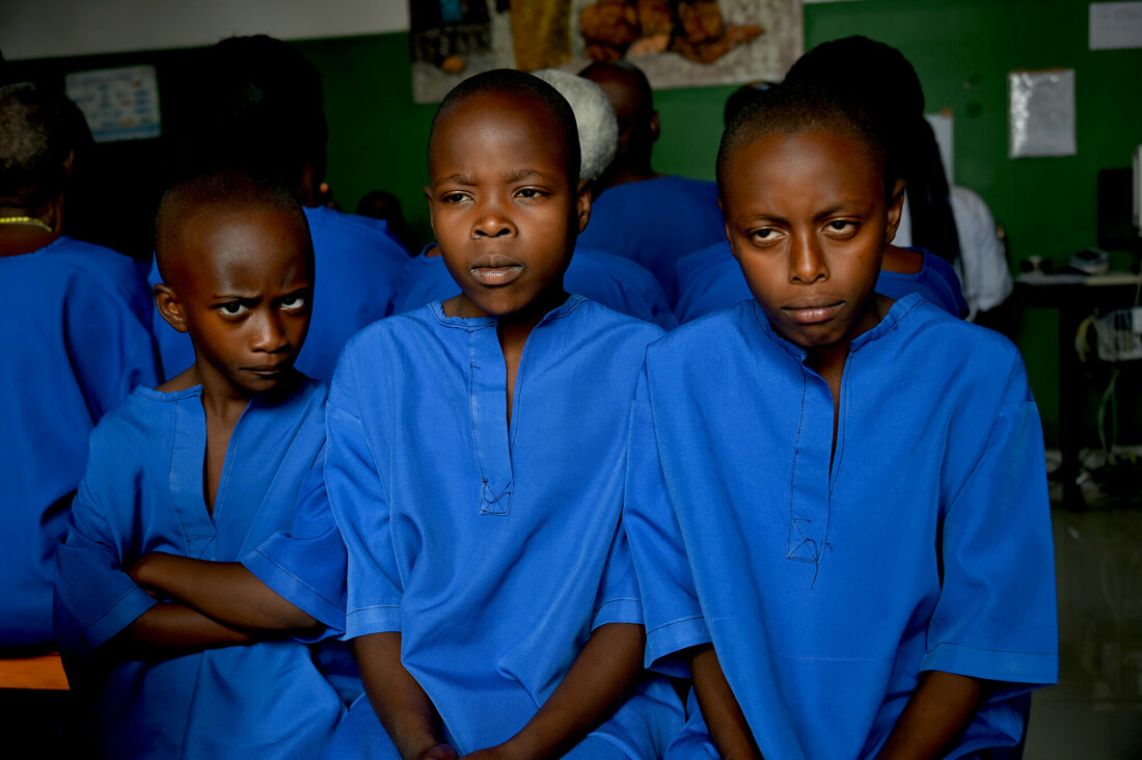 Drei ernst blickende Mädchen, die blaue Hemden tragen.