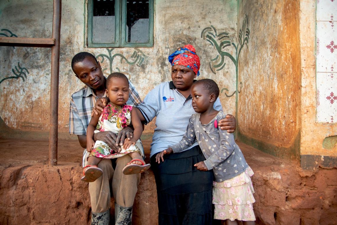 Ein Mann leuchtet mit einer Taschenlampe in die Augen eines Kleinkindes.