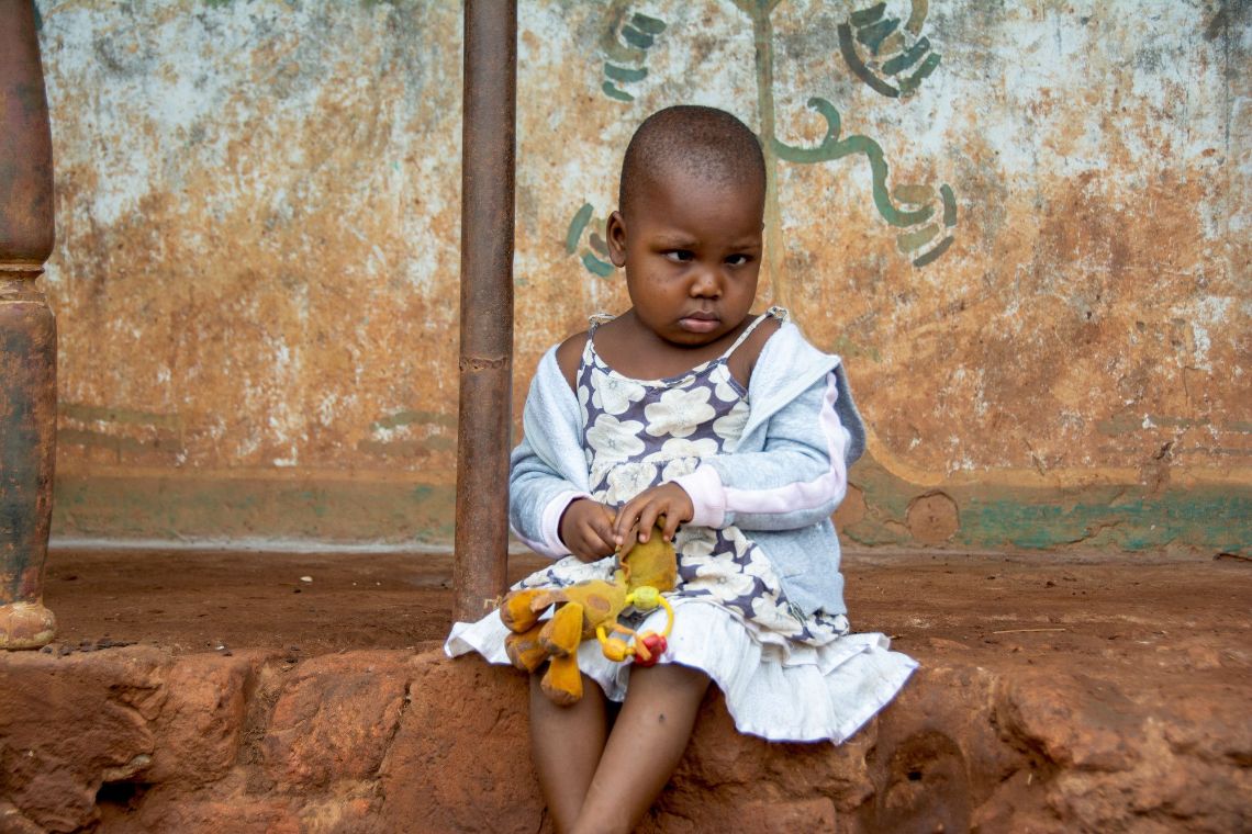 Ein Mann leuchtet mit einer Taschenlampe in die Augen eines Kleinkindes.