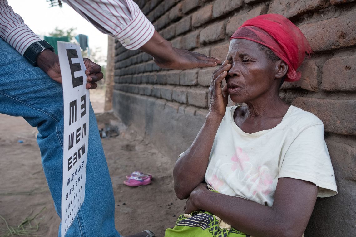 Sehtest bei einer Frau in einem malawischen Dorf
