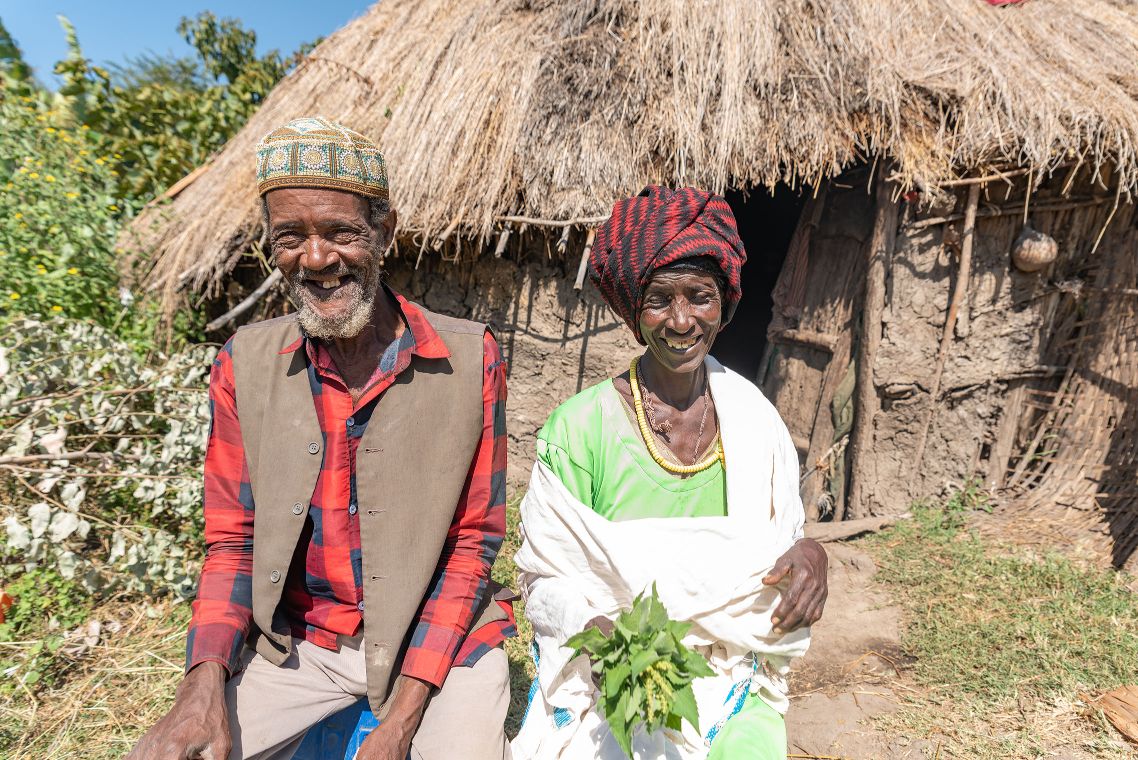 Ehefrau und -mann sitzen lächelnd nebeneinander