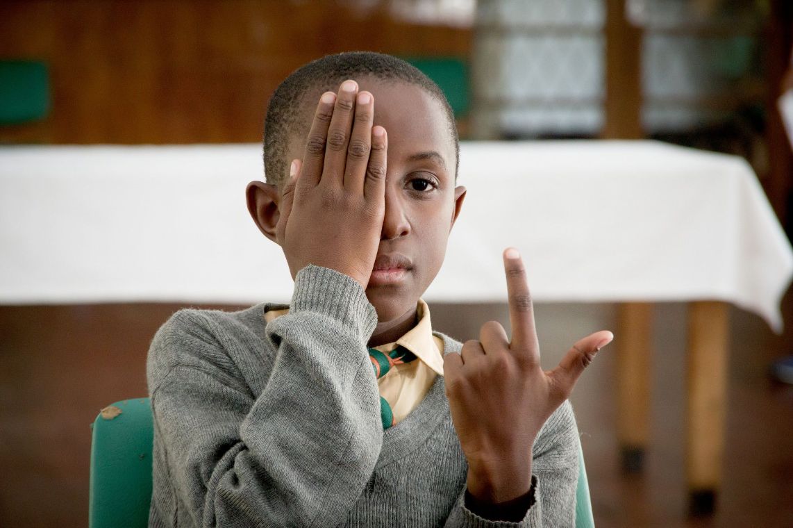Eine Frau hält ein Smartphone hoch, auf dem ein E zu sehen ist