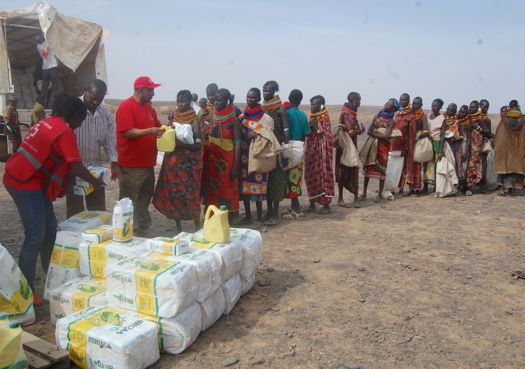 Viele afrikanische Menschen warten in einer Schlange an einer Essensausgabe.