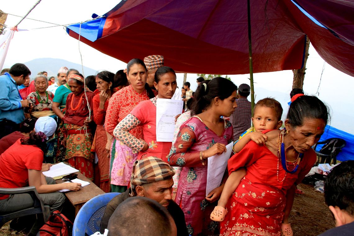 Mehre Menschen stehen in einer Warteschlange.