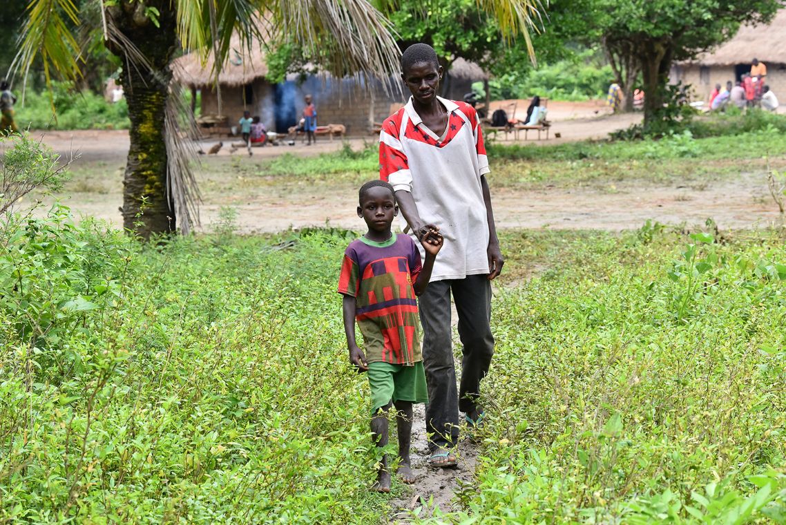 Ein Mann wird von seinem Sohn an der Hand geführt.