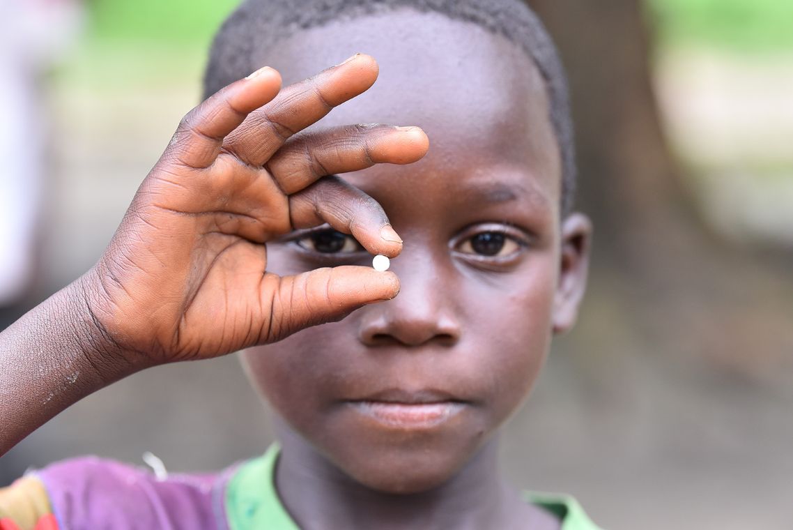 Ein Junge hält mit der Hand eine Tablette vors Gesicht.