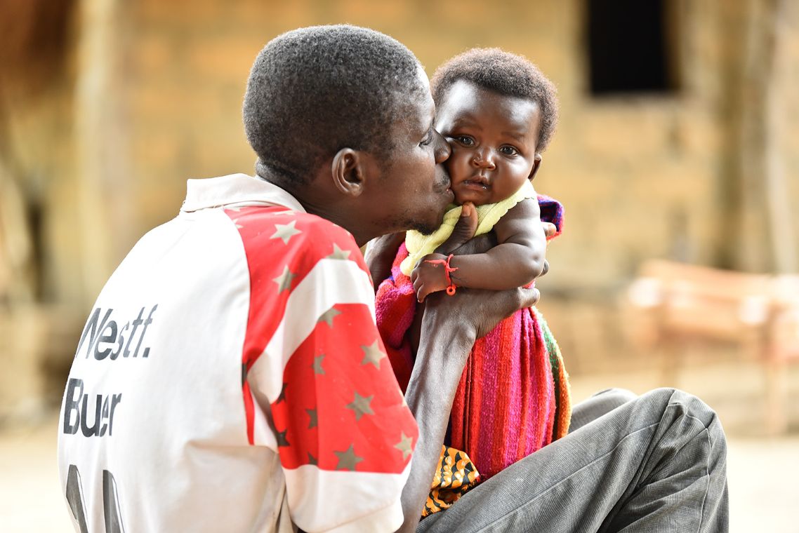 Ein Mann mit Kind im Arm.