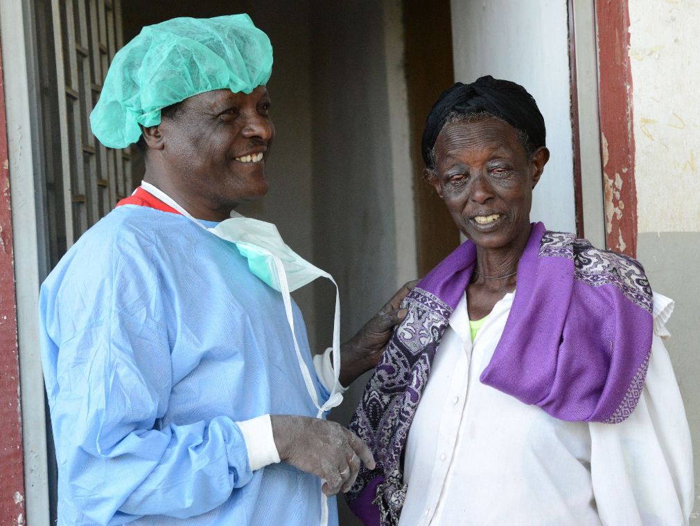 Ein Mann streicht einem Kind Salbe in die Augen.