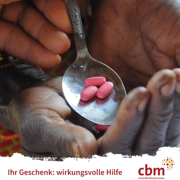 Eine Hand hält einen Löffel, auf dem drei Tabletten liegen