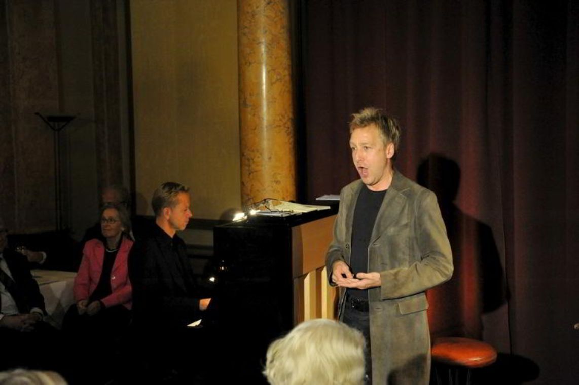 Singender Mann neben einem Pianisten am Flügel