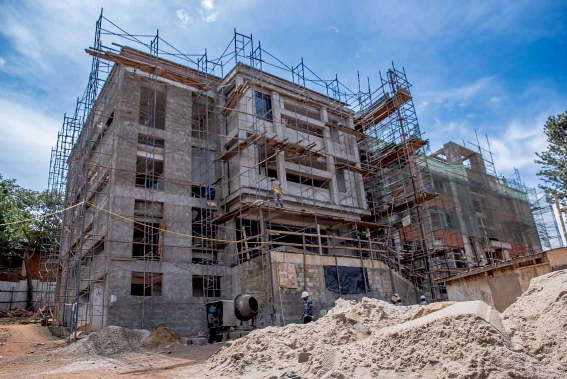 Viergeschossiges eingerüstetes Betongebäude im Rohbau.