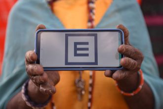 Eine Person hält einen Handyscreen mit Sehtest vor sich hoch