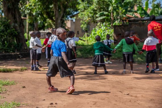Ein etwa vierjähriger Junge mit etxremen O-Beinen geht einen unbefestigten Weg entlang.