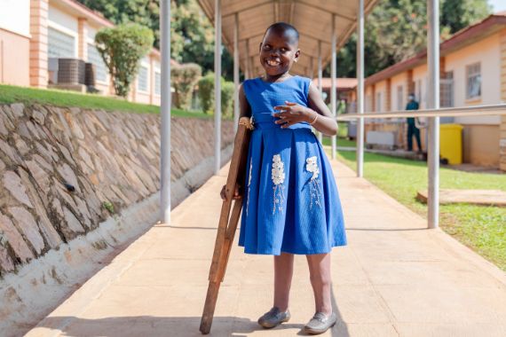 Afrikanisches Mädchen mit Unterarmstützen aus Holz