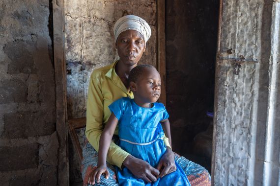 Portrait einer Mutter mit ihrer Tochter auf dem Schoß.