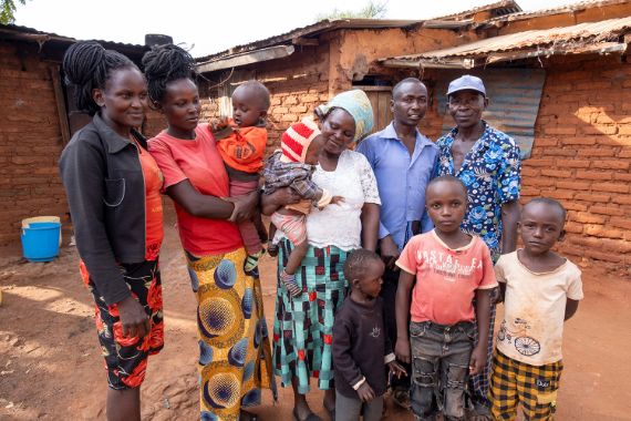 Ein Mann geht an Krücken zwischen Maispflanzen hindurch. Text auf dem Bild: Aus 1 wird 4. Jeder Euro zählt!
