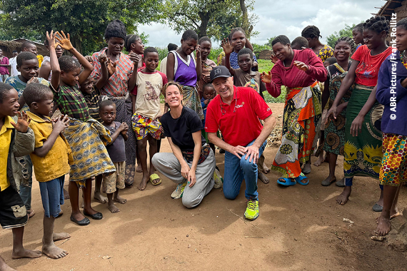 Eine Gruppe von Menschen. Zwei Personen knien. 