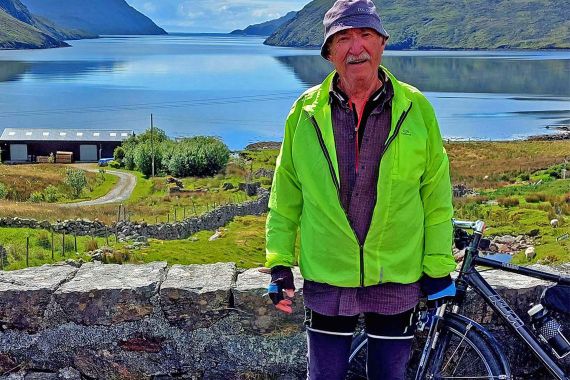 Älterer Mann mit Fahrrad vor einem See