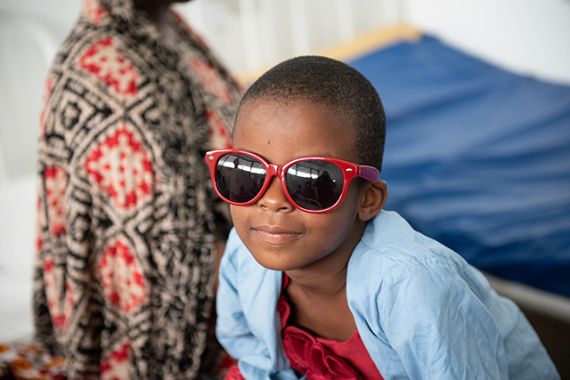 Ein Mädchen trägt eine Sonnenbrille.