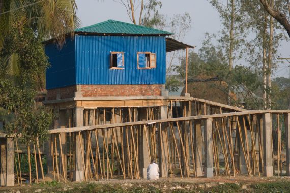 Ein Haus auf Stelzen mit einer langen, gewundenen Rampe.