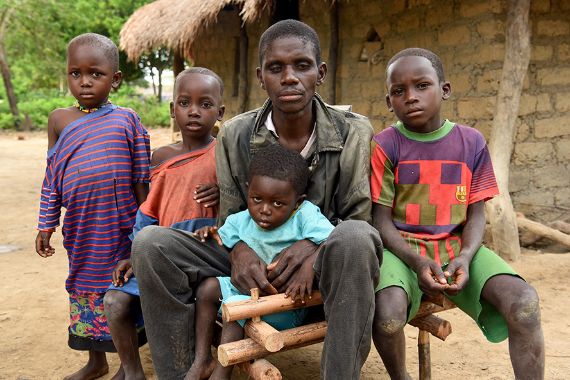 Ein Mann und vier Kinder sitzen auf einer Bank.