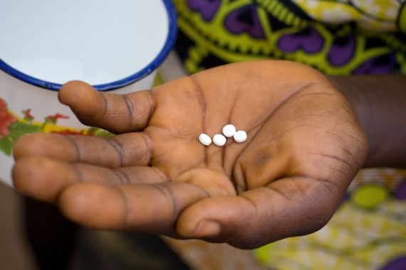 Eine Frau hat Medikamente gege Flussblindheit in der Hand.