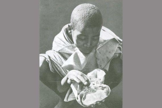 Ein Kind hält etwas zum Essen in den Händen. In Äthiopien herrschte 1974 eine verheerende Dürre, die zur Hungersnot führte.